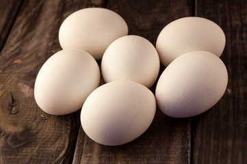 Raw fresh white farmer's chicken eggs on rustic wooden background. Healthy and sport food. Easter theme.
