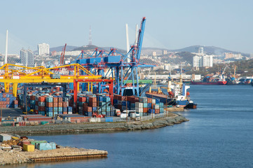 Container terminal in the seaport. Unloading cargo ships in dock.  Cranes and containers on the...