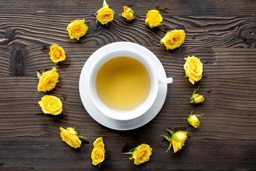 herbal tea with yellow flowers on wooden table background top view