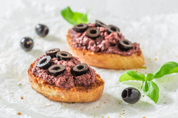 Fresh bruschetta with black olives for a snack