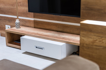 Modern wooden commode for tv set in living room interior