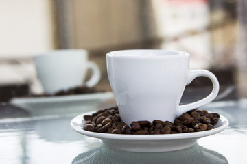 Espresso coffee. Coffee beans on a saucer and a small white cup