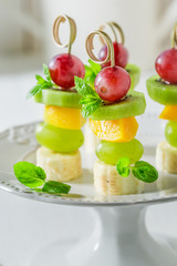 Tasty skewers with various fruits and mint for snack