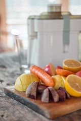 Juicer surrounded by healthy fruits and vegetables