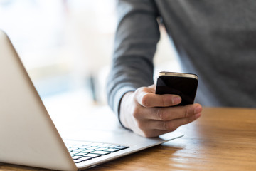 Incognito businessman with cell phone in one hand.