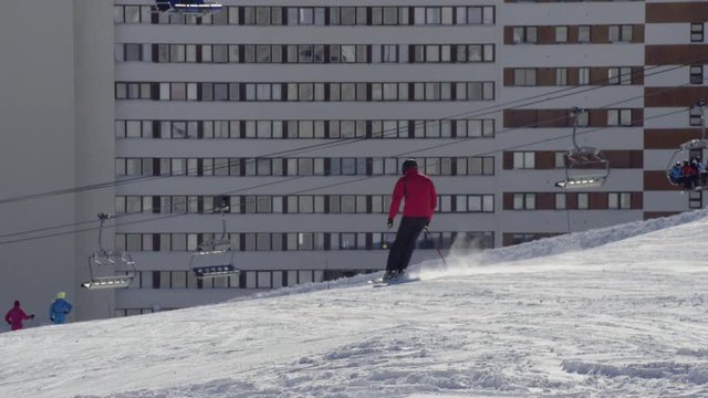 Ski lift in resort, skiers go past