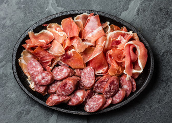 Plate of spanish meat tapas - jamon serrano and salamy