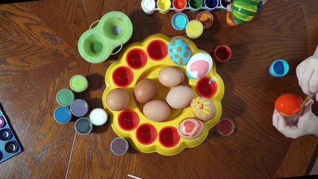 Mom and daughter are preparing for Easter. paint eggs. Top view