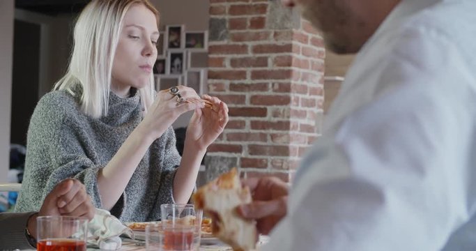 multiethnic group of friends people enjoy having lunch or dinner meal together eating pizza indoor in modern industrial house. 4k handheld slow motion video shot