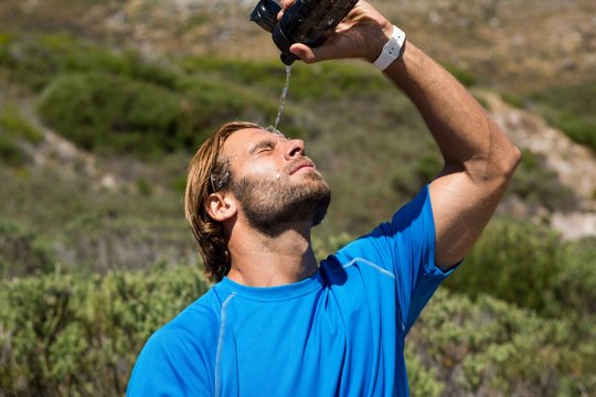 Athlete putting water on face 