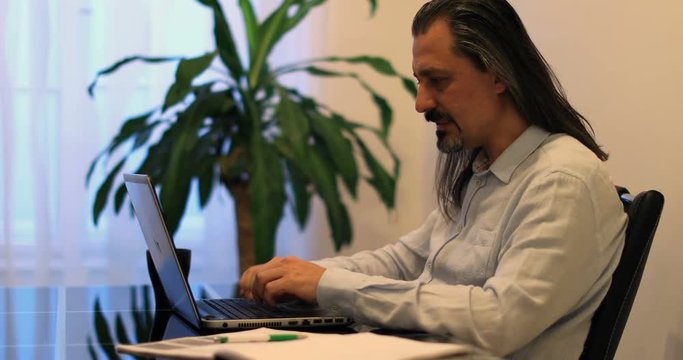 middle age attractive handsome man using laptop at office