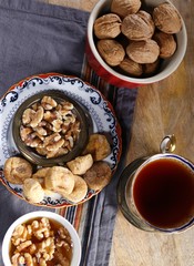 Cup of brewed tea with eastern sweets and spices on wooden table
