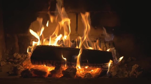 Warm cozy fire in a Home Fireplace. Real wood Burning in a Brick Fireplace Slow Mo. Autumn and Winter holidays. Home cosiness. Medium Shot
