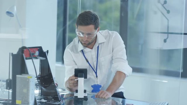 Electronic engineer working in the lab, testing 3D printer & circuit boards