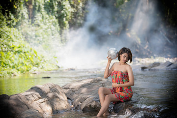 Asian woman take a bath in waterfall ,thailand
