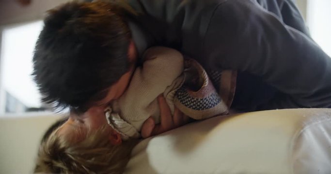 modern family dad hugs and playing with his son or daughter indoor in modern industrial house. caucasian. 4k handheld close up video shot