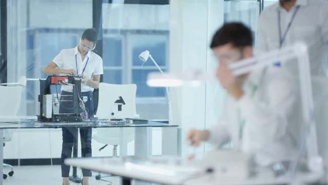  Electronic engineering team working in the lab, testing 3D printer & circuit 