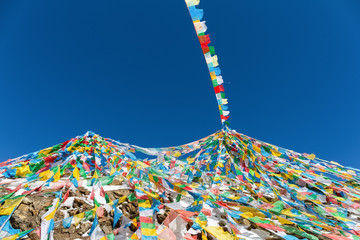 the wind-horse flags against a blue sky in tibet