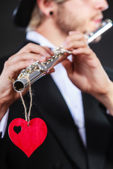 Male flutist with flute and heart. Love melody