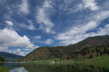 Fototapeta premium Lake reflecting blue sky clouds and mountain