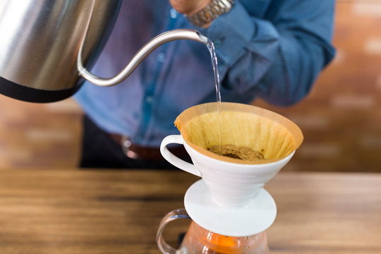 Barista Pouring Water On Coffee Filter