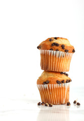 Chocolate chip muffins stacked on top of each other on a white isolated background 