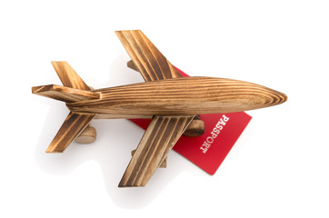top view airplane model on top of a red passport on white background