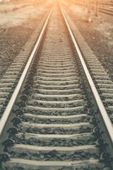 Fototapeta na wymiar railway track on gravel for train transportation with sunset light tone