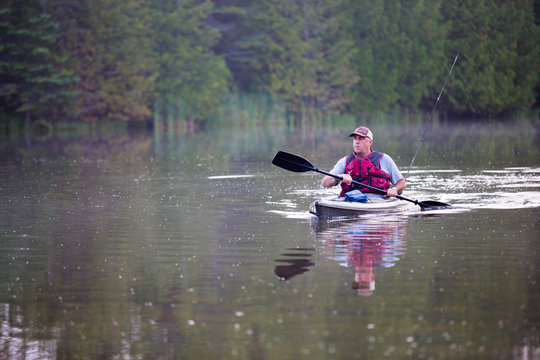 Middle aged man kayak fishing