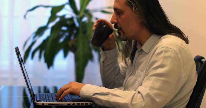 middle age attractive handsome man using laptop at office