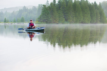Middle aged man kayak fishing