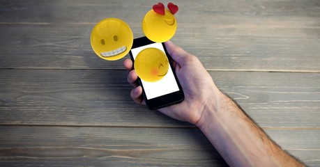 Emojis coming out of smart phone held by man