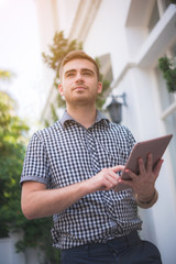 young man using tablet with building background  