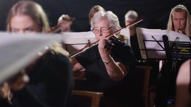  Symphony orchestra during a performance with focus on violinists. 