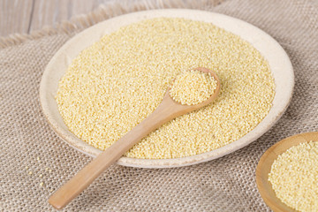 Yellow millet seeds in a wooden bowl on the table
