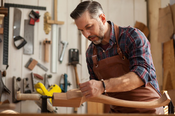 Joiner Makes Cabriole Leg for Vintage Table/Carpenter works with a planer in a workshop for the...