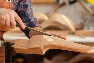 Exquisite Lines of the Cabriole's Legs/Carpenter works with a planer in a workshop for the...