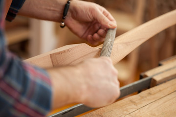 Exquisite Lines of the Cabriole's Legs/Carpenter works with a planer in a workshop for the production of vintage furniture. He makes cabriole leg for a table in the style of Louis XV