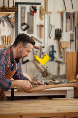 Joiner Makes Cabriole Leg for Vintage Table/Carpenter works with a planer in a workshop for the production of vintage furniture. He makes cabriole leg for a table in the style of Queen Anne