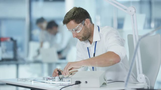  Electronics engineer working in lab building & testing electronic devices