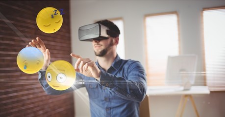 Businessman looking at emojis through VR glasses