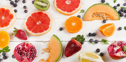 Fresh mixed fruits on a white wooden background. Healthy food concept.