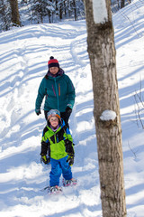 Fototapeta na wymiar Mother and sun snowshoeing in Ontario, Canada