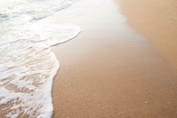 Soft wave of blue ocean on sandy beach at sunny day.