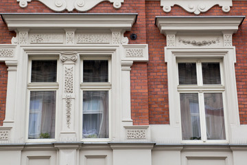 Three vintage design windows on the facade of the old house