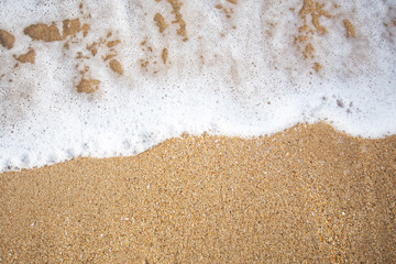 Soft wave of blue ocean on sandy beach at sunny day.