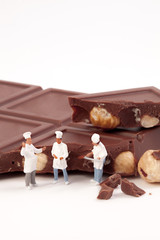 Miniature people: A chef and cooks in front of a chocolate bar