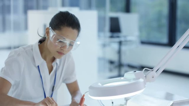  Electronic engineers working in the lab, testing 3D printer & circuit boards