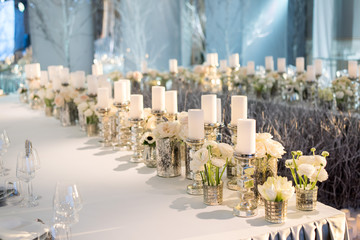 Banquet table decor. Candles in vases and flowers