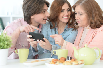 Happy family using mobile phone together